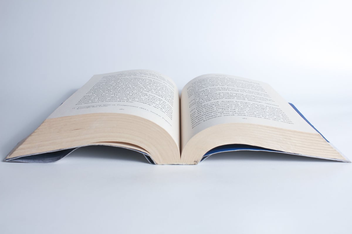 Libro abierto en fondo blanco que representa la guía gratuita de Kinesy Health Center